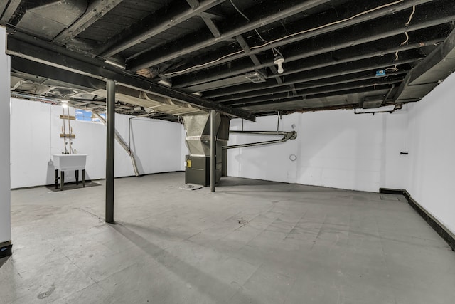 basement featuring heating unit and sink