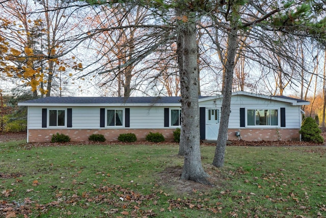 ranch-style home featuring brick siding and a front lawn