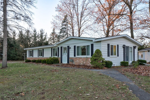 single story home featuring a front yard and brick siding