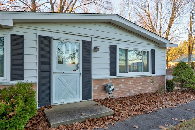 view of exterior entry featuring brick siding