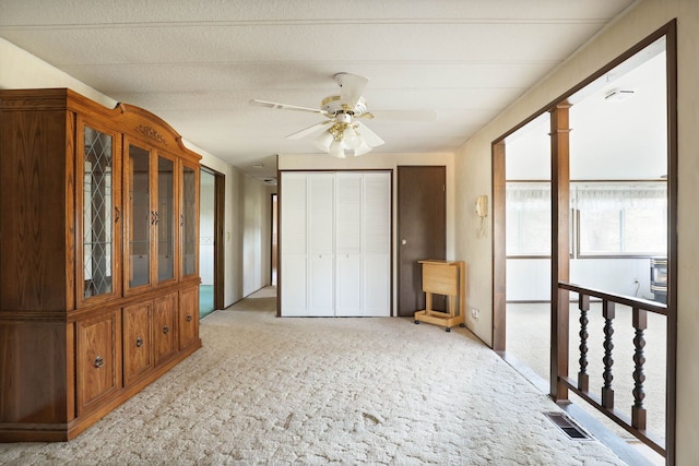 bedroom featuring ceiling fan, visible vents, a closet, and light colored carpet