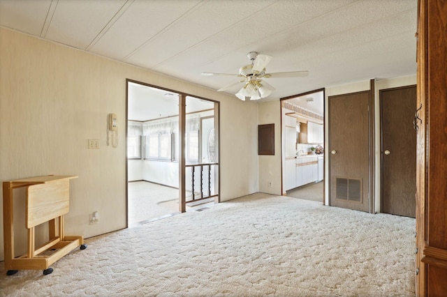 carpeted empty room featuring ceiling fan and visible vents