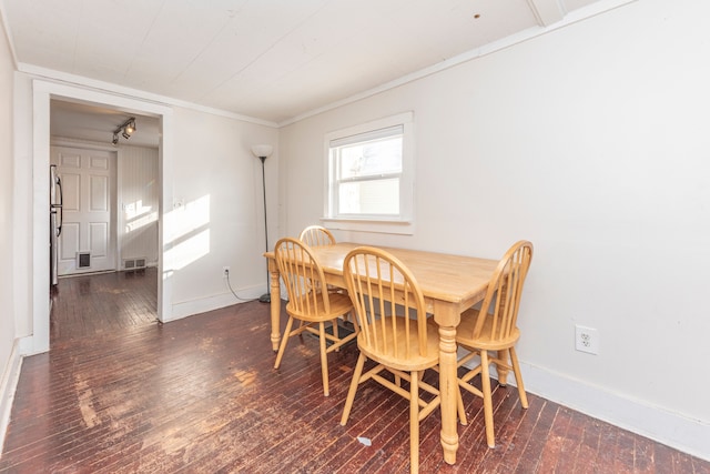 dining space with dark wood-type flooring and crown molding