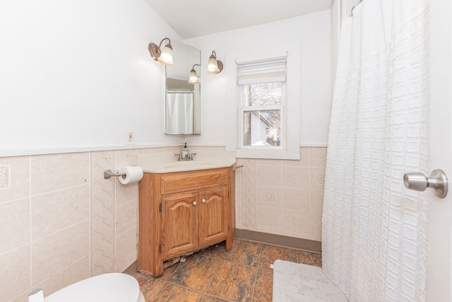 bathroom featuring tile walls, toilet, and vanity