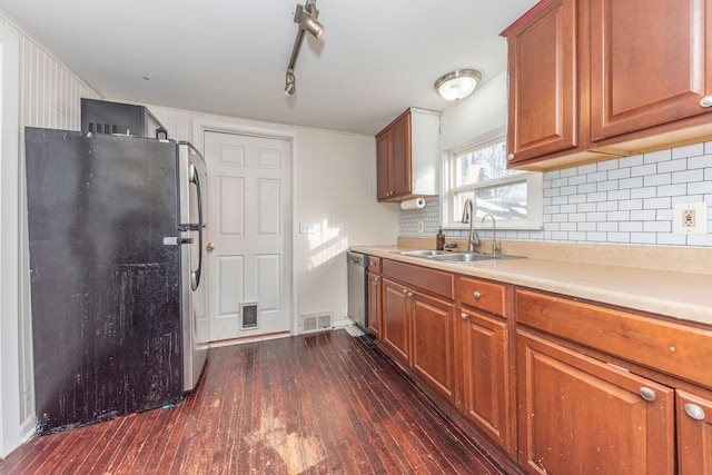 kitchen featuring appliances with stainless steel finishes, track lighting, dark hardwood / wood-style floors, and sink