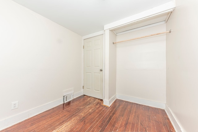 unfurnished bedroom featuring a closet and dark hardwood / wood-style floors