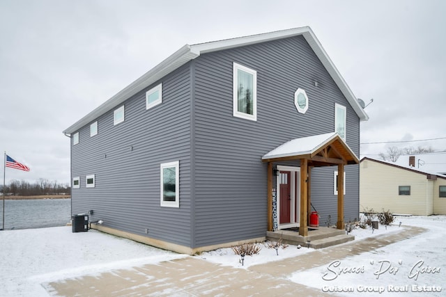 snow covered back of property with central AC