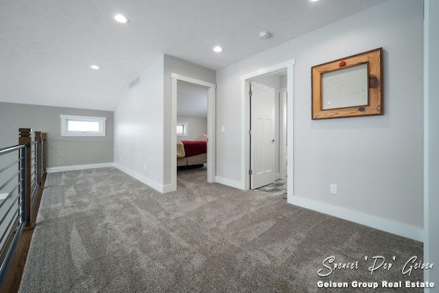 interior space with carpet floors and vaulted ceiling