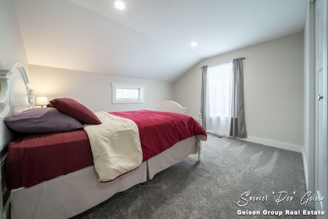 carpeted bedroom featuring multiple windows and lofted ceiling