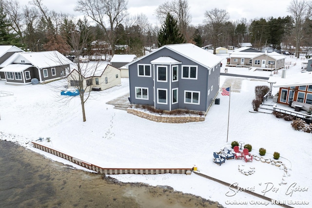 view of snow covered back of property