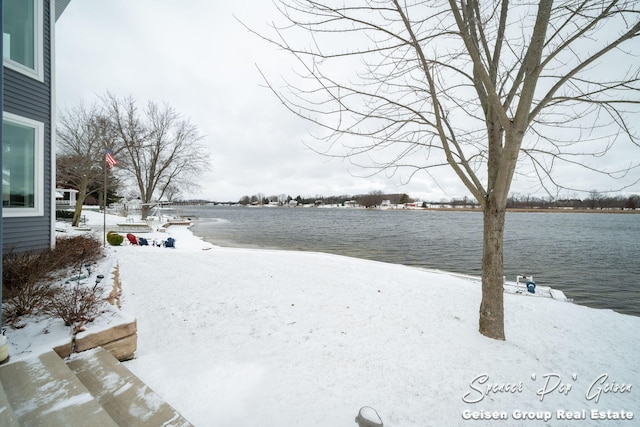 yard covered in snow with a water view