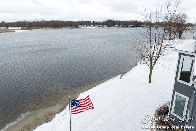 snowy aerial view featuring a water view