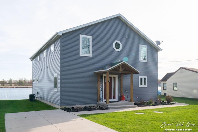 traditional home featuring a water view, a front lawn, and cooling unit