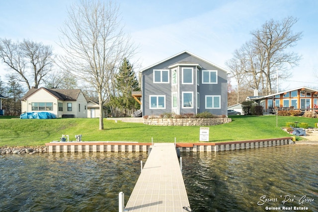 back of property with a lawn and a water view