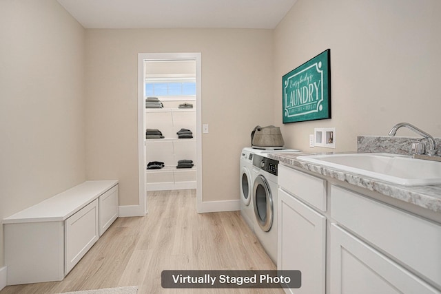 2519 Hunters Run Unit 101, Kalamazoo, MI 49048 - laundry room featuring washer and dryer, sink, cabinets, and light wood-type flooring