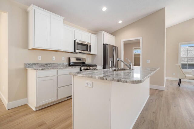 2519 Hunters Run Unit 101, Kalamazoo, MI 49048 - kitchen featuring white cabinets, a center island with sink, sink, vaulted ceiling, and stainless steel appliances
