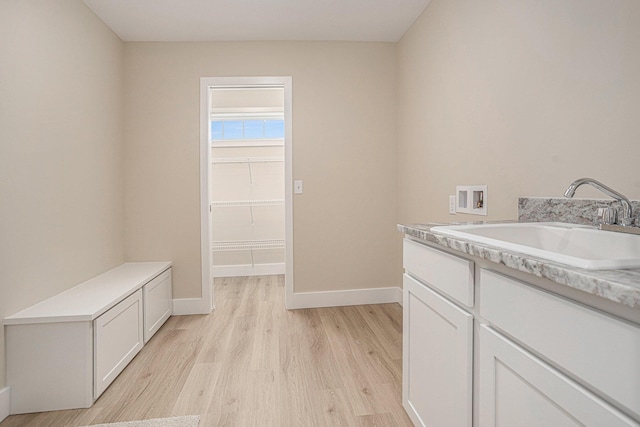 2519 Hunters Run Unit 101, Kalamazoo, MI 49048 - laundry area with hookup for a washing machine, sink, cabinets, and light wood-type flooring