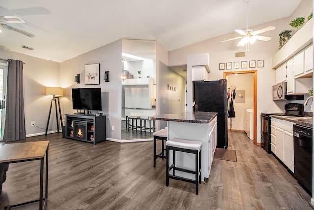 kitchen featuring ceiling fan, white cabinetry, black appliances, a breakfast bar area, and lofted ceiling