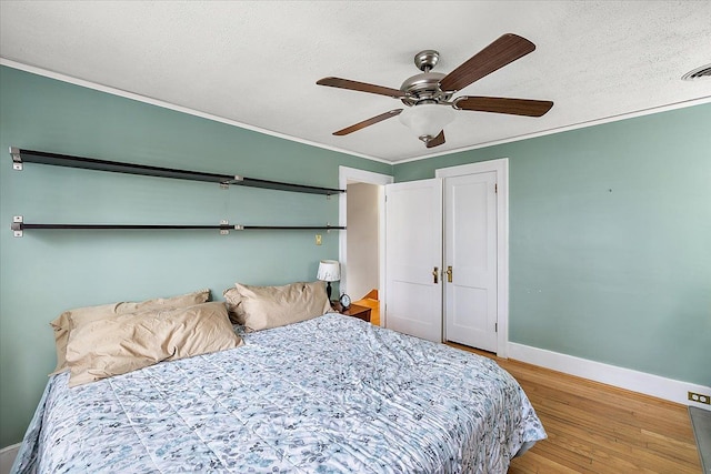 bedroom with wood-type flooring, ceiling fan, and ornamental molding