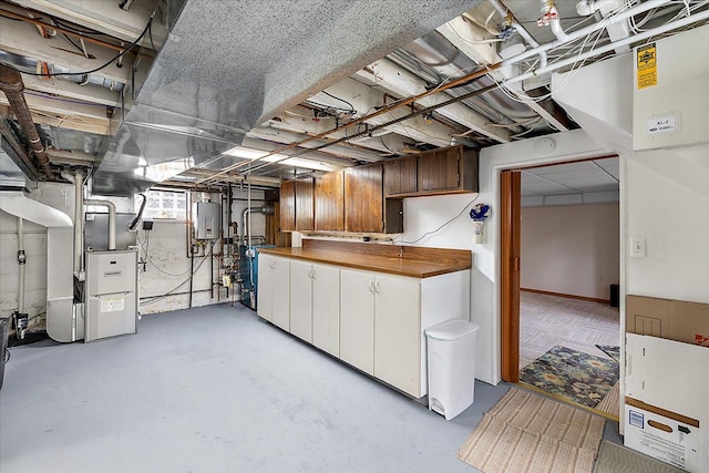 basement featuring heating unit and water heater