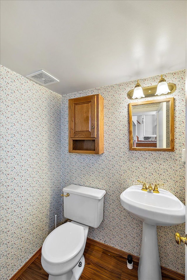 bathroom featuring hardwood / wood-style floors and toilet