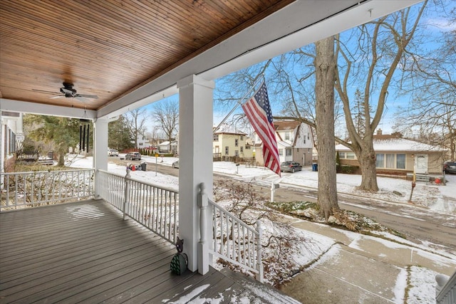 snow covered deck featuring ceiling fan and covered porch