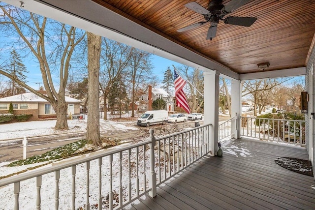 snow covered deck with ceiling fan and a porch