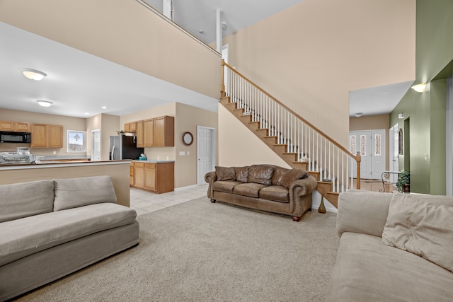 3700 Marie Meadows Dr, White Lake, MI 48383 - living room featuring stairway, light colored carpet, a towering ceiling, light tile patterned flooring, and baseboards