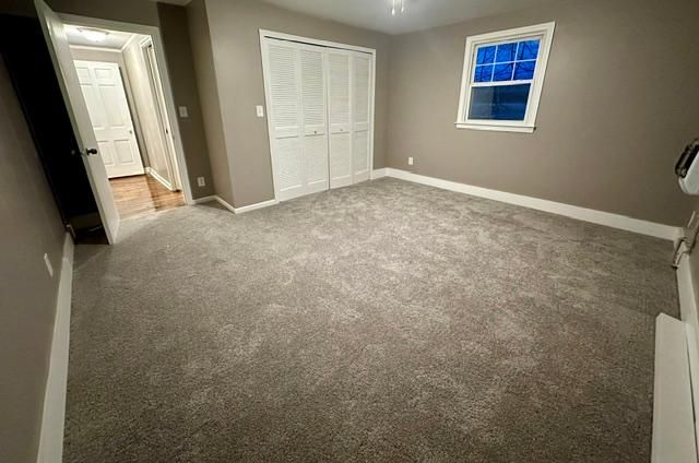 unfurnished bedroom featuring a closet, baseboards, and carpet flooring