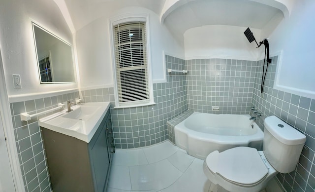 full bathroom featuring toilet, vanity, tile patterned flooring, tile walls, and lofted ceiling