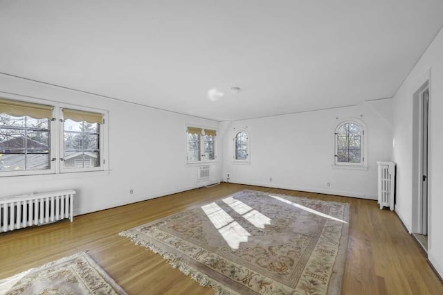 empty room featuring radiator heating unit and wood-type flooring