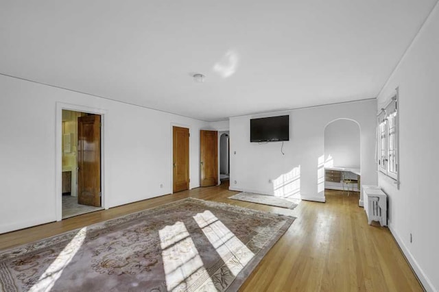 unfurnished bedroom with radiator heating unit and light hardwood / wood-style flooring