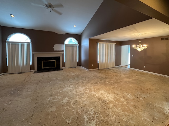 unfurnished living room featuring lofted ceiling, a wealth of natural light, and ceiling fan with notable chandelier