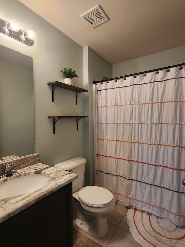 bathroom featuring toilet, vanity, tile patterned floors, and walk in shower