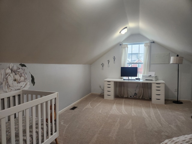 carpeted bedroom featuring vaulted ceiling and a nursery area