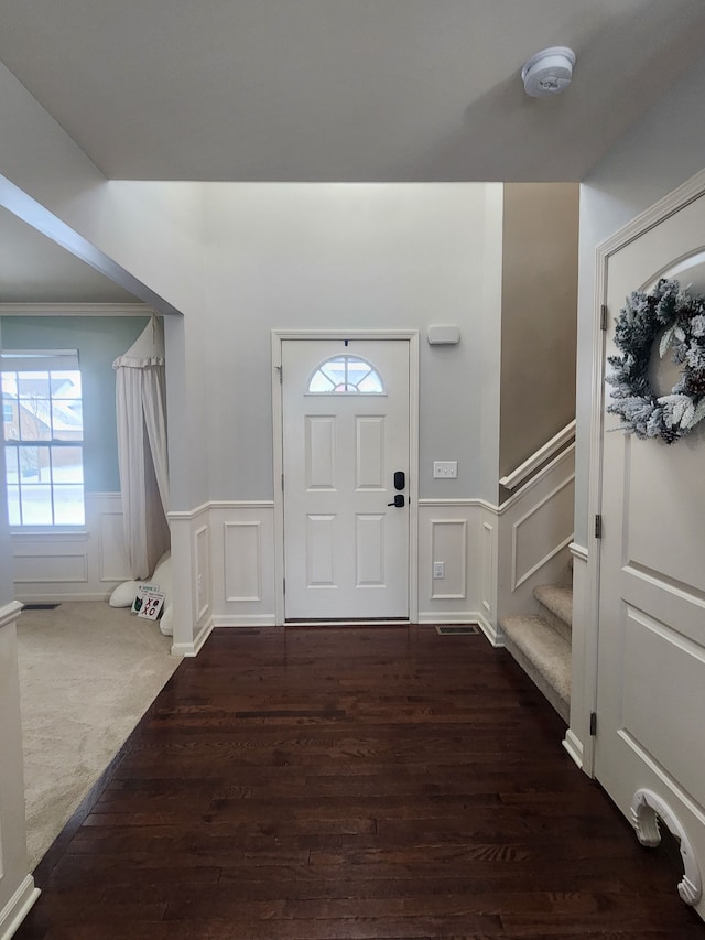 foyer with dark hardwood / wood-style flooring and crown molding