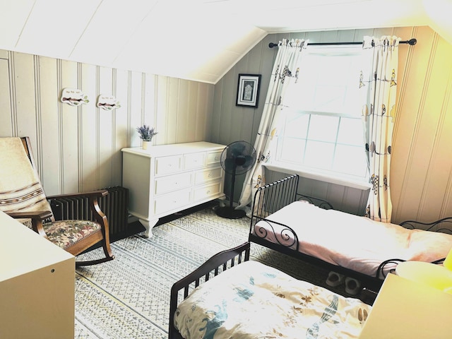 bedroom with lofted ceiling and wooden walls