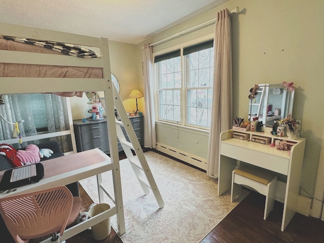 bedroom with wood-type flooring, a textured ceiling, and a baseboard heating unit