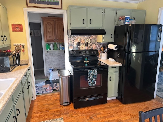 kitchen featuring backsplash, light hardwood / wood-style flooring, and black appliances