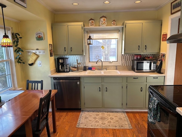 kitchen featuring sink, hanging light fixtures, light hardwood / wood-style flooring, decorative backsplash, and appliances with stainless steel finishes