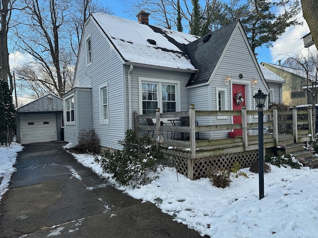 view of front of home with a garage and an outbuilding