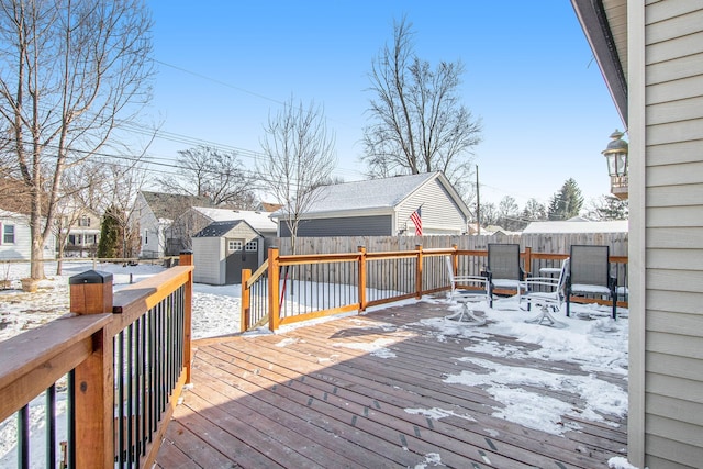 snow covered deck with a storage shed