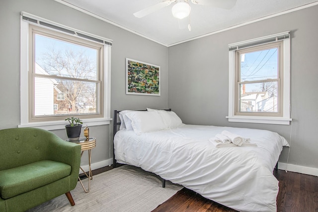 bedroom featuring ceiling fan, dark hardwood / wood-style floors, crown molding, and multiple windows