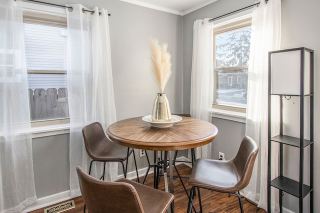 dining space with wood-type flooring and ornamental molding