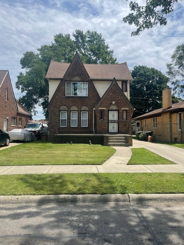 english style home with a front lawn