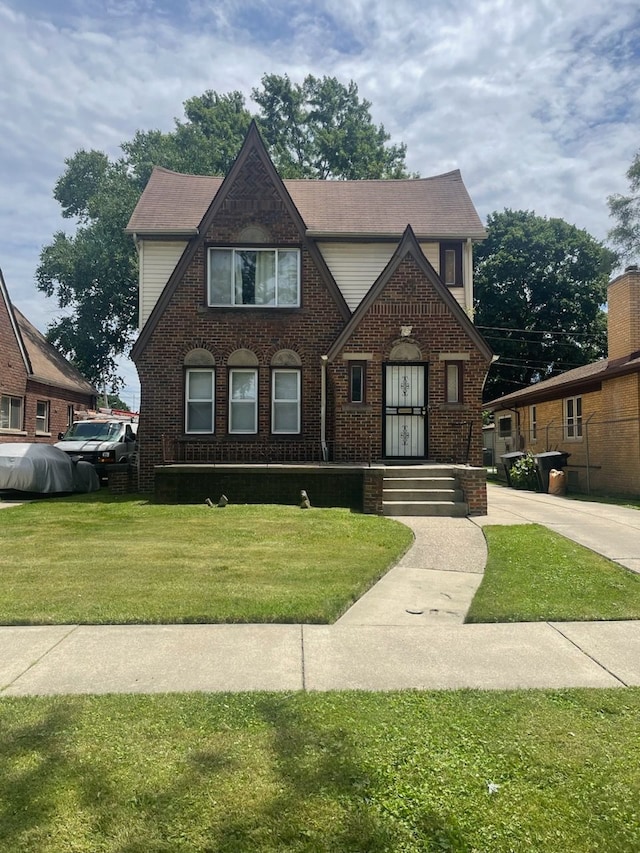 tudor-style house featuring a front lawn