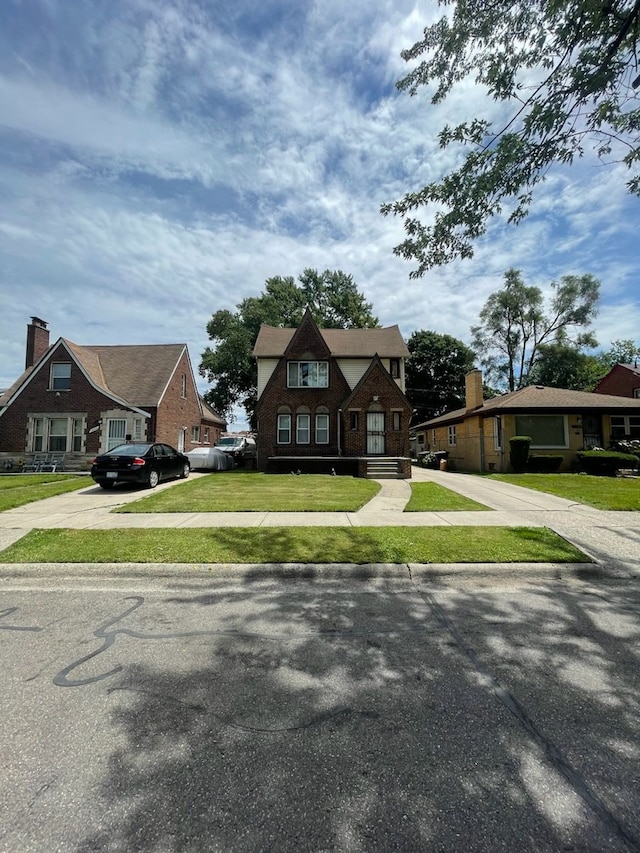 tudor home featuring a front lawn