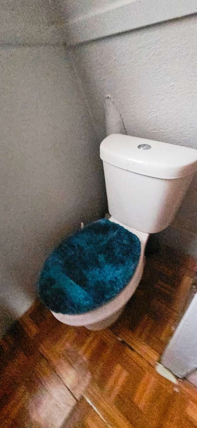 bathroom with hardwood / wood-style flooring and toilet