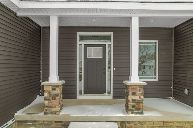 view of exterior entry featuring covered porch