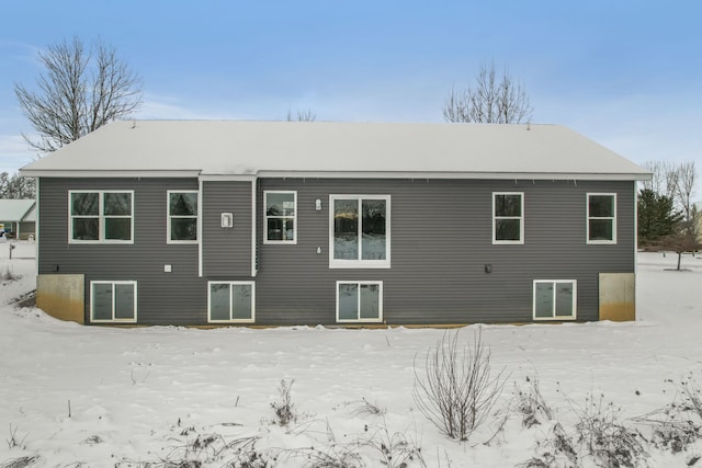 view of snow covered back of property